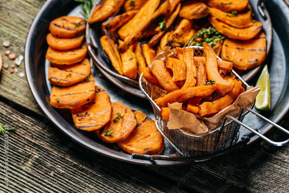 Wall mural fried sweet potatoes with rosemary, paprika and chili peppers on white plate. food recipe background