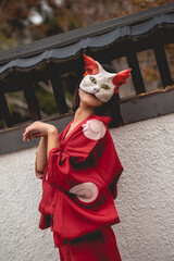 Portrait of sexy and young japanese girl with beautiful old traditional red kimono and handmade cat...