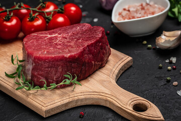 Beef tenderloin fillet with rosemary and spices on a dark background. Preparing fresh beef steak ready to cook, Long banner format. top view