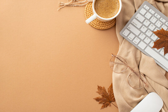 Autumn business concept. Top view photo of cup of hot drinking rattan serving mat computer mouse keyboard fallen maple leaves spectacles and plaid on isolated beige background with empty space