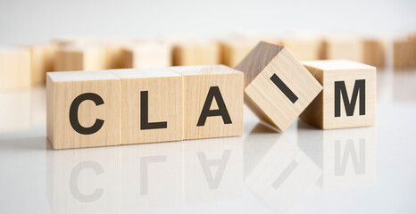 the word claim written on wooden cubes with assets icon on white background. asset management or financial accounting concept