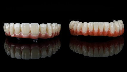 two dental prostheses of the upper and lower jaws with gums and relief of teeth on black glass with reflection