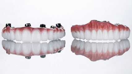 two dental prostheses made of zircon and titanium on a white background with reflection