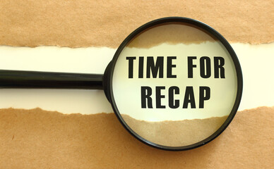 The magnifying glass reveals the TIME FOR RECAP text appearing behind the torn brown paper.