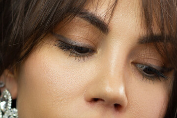 Beautiful macro shot of female eye with classic eyeliner makeup. Perfect shape of eyebrows, brown...