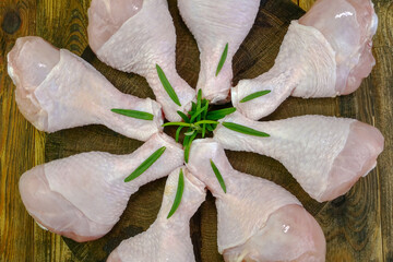Fresh raw chicken drumsticks with rosemary twigs. - 521066796