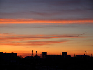 Bright sunset sky over the silhouette of the evening city.