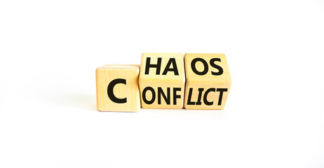 From conflict to chaos symbol. Concept words Conflict and Chaos on wooden cubes. Beautiful white table white background. Businessman hand. Business Conflict and Chaos concept. Copy space.