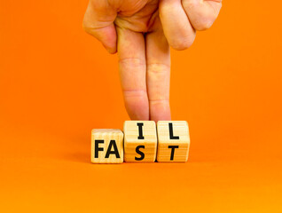 Fail fast symbol. Concept words Fail fast on wooden cubes. Businessman hand. Beautiful orange table orange background. Business and fail fast concept. Copy space.