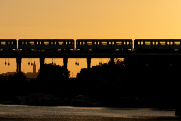 Paris metro train passing over the Seine river at dawn.