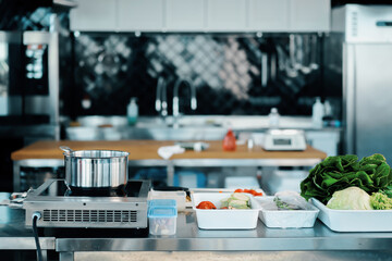 The interior of a professional kitchen in a restaurant. Food items are ready to be cooked.