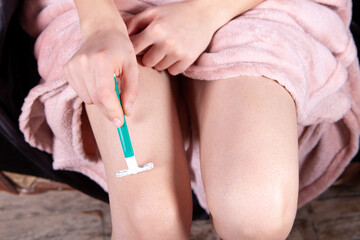 Obraz na płótnie Canvas young girl shaves her leg
