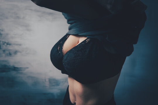 young woman in bra takes off her t-shirt