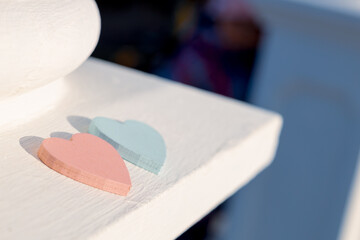 a red and blue wood heart on the edge of a concrete fence. shallow depth of field