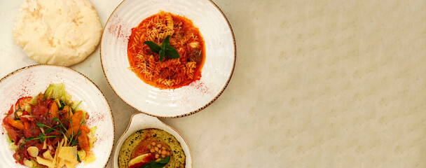 Dishes of Italian and Lebanese cuisine. farfalle pasta with kebab, hummus with avocado and seafood salad. Design for restaurant menu. Creative copy space. 