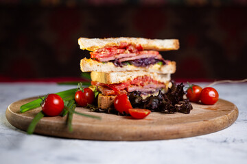 juicy crispy sandwich with ham and vegetables on the board