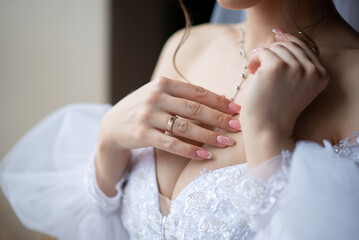 hands and breasts of the bride on the day of the wedding in the morning