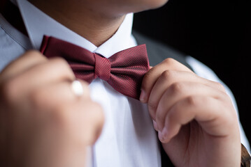 the groom straightens the bow tie before the wedding. close-up
