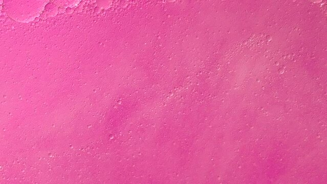 Floating oil bubbles on pink background