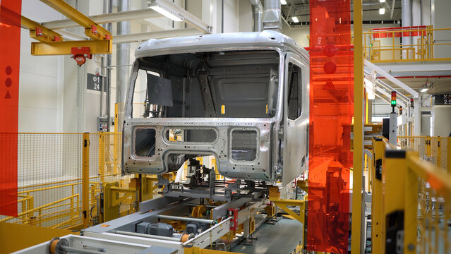 Truck body at factory. Scene. Frame of truck is moving on rails of factory. Modern equipment at truck manufacturing and assembly plant