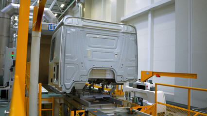 Truck body at factory. Scene. Frame of truck is moving on rails of factory. Modern equipment at...