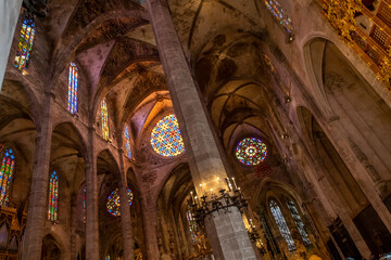 The ornate gothic interior with stained glass windows and imposing columns in the Palma de Santa Maria Cathedral of Palma, or La Seu, in the Mediterranean city of Palma de Mallorca Spain. © Kirk Fisher