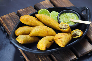 corn empanada typical Colombian food with spicy sauce and lemon