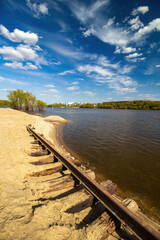 Landscape with the shore of Oka river at the mouth of Moscow river, sky, clouds and old railroad, Kolomna city, Moscow region, Russia
