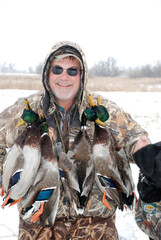 Waterfowl hunter with a strap of mallards 