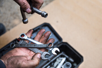 A male mechanic is sorting out wrenches