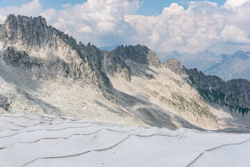 The alpine ice is being protected from global warming. Presena glacier in northern Italy protected from the sun with huge reflective tarps. - 521080964