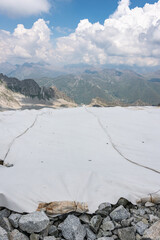 The alpine ice is being protected from global warming. Presena glacier in northern Italy protected from the sun with huge reflective tarps. - 521080997
