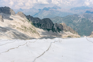 The alpine ice is being protected from global warming. Presena glacier in northern Italy protected from the sun with huge reflective tarps. - 521080999