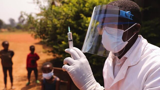 African doctor prepares the syringe for vaccinating children, health care and medicine in Africa.