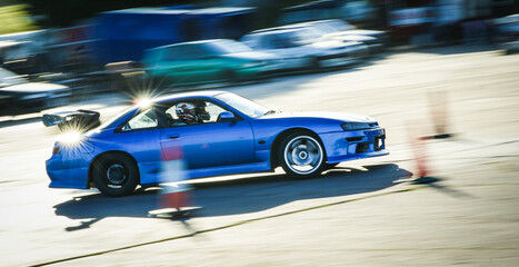 Stunt drivers race and drift their modified Japanese cars on a sunny track day in Somerset, England © Ambrosiniv