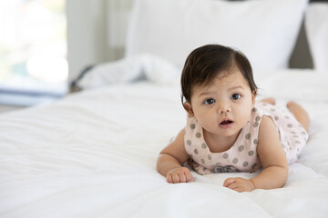 portrait cute baby crawling on bed and looking to something