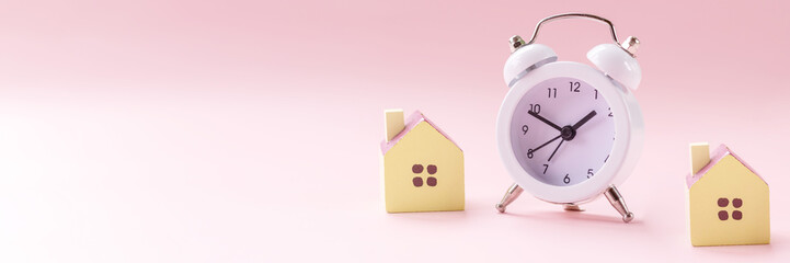 Miniature toy house standing near clock .Dream house,Real estate concept.Close-up.Selective focus.Time to buy new house, flat.Mortgage ,investment concept. copy space.web banner