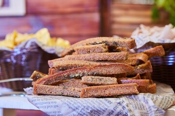 Loaves and crackers lie on newsprint. Light snack and table decoration.