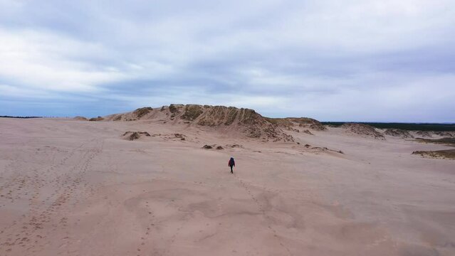 Aerial Wide Shot Of a Tourist Walking on an Endless Sands Towards the Horizon