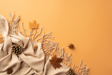 Autumn inspiration concept. Top view photo of autumn maple leaves scarf anise and pine cones on isolated orange background