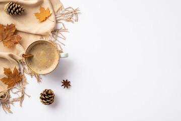 Autumn inspiration concept. Top view photo of cup of hot drinking with cinnamon stick yellow maple leaves anise pine cones and plaid on isolated white background with copyspace