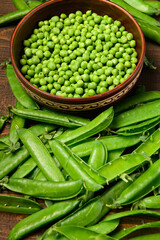 green sweet peas on a dark wooden background, still life, concept of fresh and healthy food