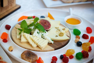 Different assortment of cheese on a plate. Menus for restaurants and cafes. Decoration with various ingredients.