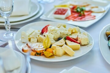 Different assortment of cheese on a plate. Menus for restaurants and cafes. Decoration with various ingredients.