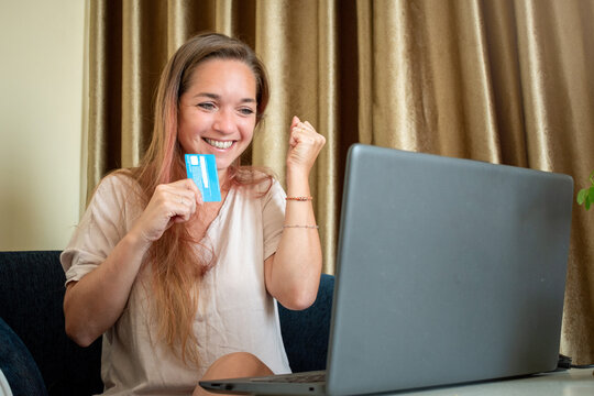Mujer feliz despu&eacute;s de realizar una compra on-line con su computadora