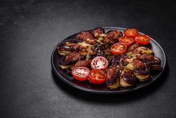 Fresh eggplant baked with minced meat, spices and herbs on a black plate