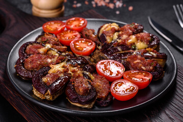 Fresh eggplant baked with minced meat, spices and herbs on a black plate