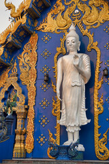 Standing Buddha, all white.  In front of a church in a Rong Suea Ten temple (blue Thai temple).