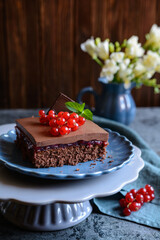 Cocoa dessert with red currant filling, topped with chocolate mousse and fresh berries