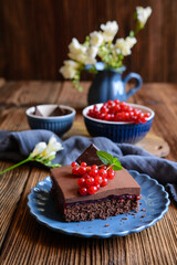 Cocoa dessert with red currant filling, topped with chocolate mousse and fresh berries